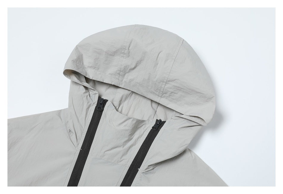 Close-up of a light gray jacket hood and front with two black zippers.