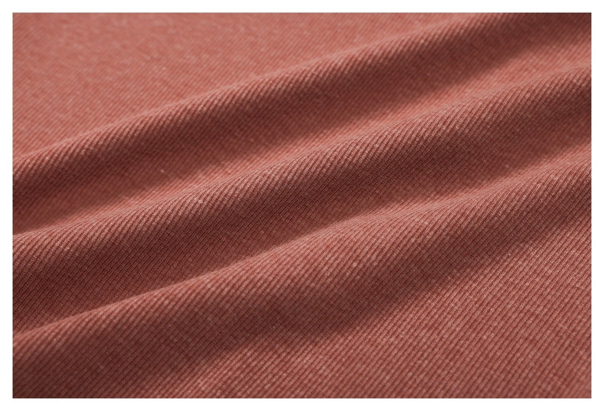Close-up of dusty rose ribbed fabric arranged in soft folds.