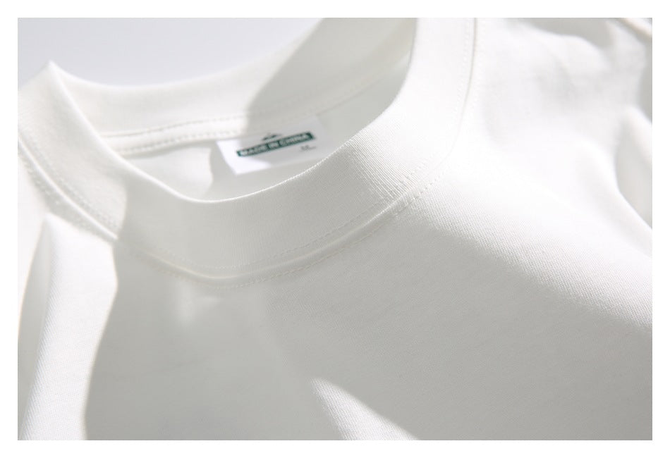 Close-up of the white T-shirt's ribbed crew neckline, stitching, and inside label marked “Made in China.”