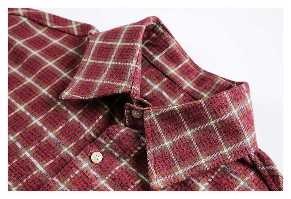 Close-up of a red plaid shirt collar, neckline, and light-colored buttons.