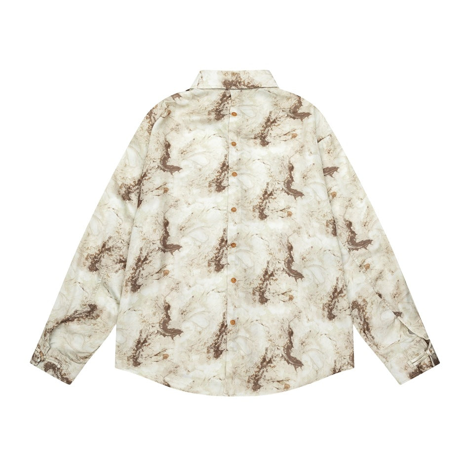Back view of a cream long-sleeved button-up shirt with brown marbled print, laid flat.