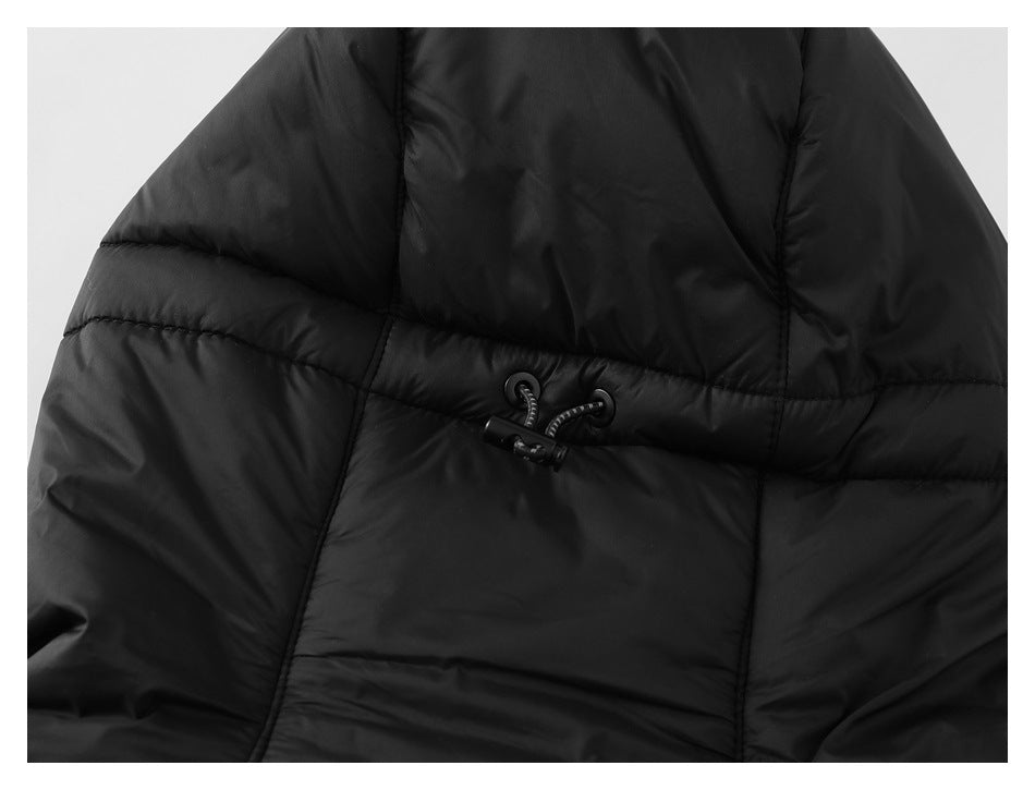 Close-up of a black quilted jacket showing a small cord and toggle closure.