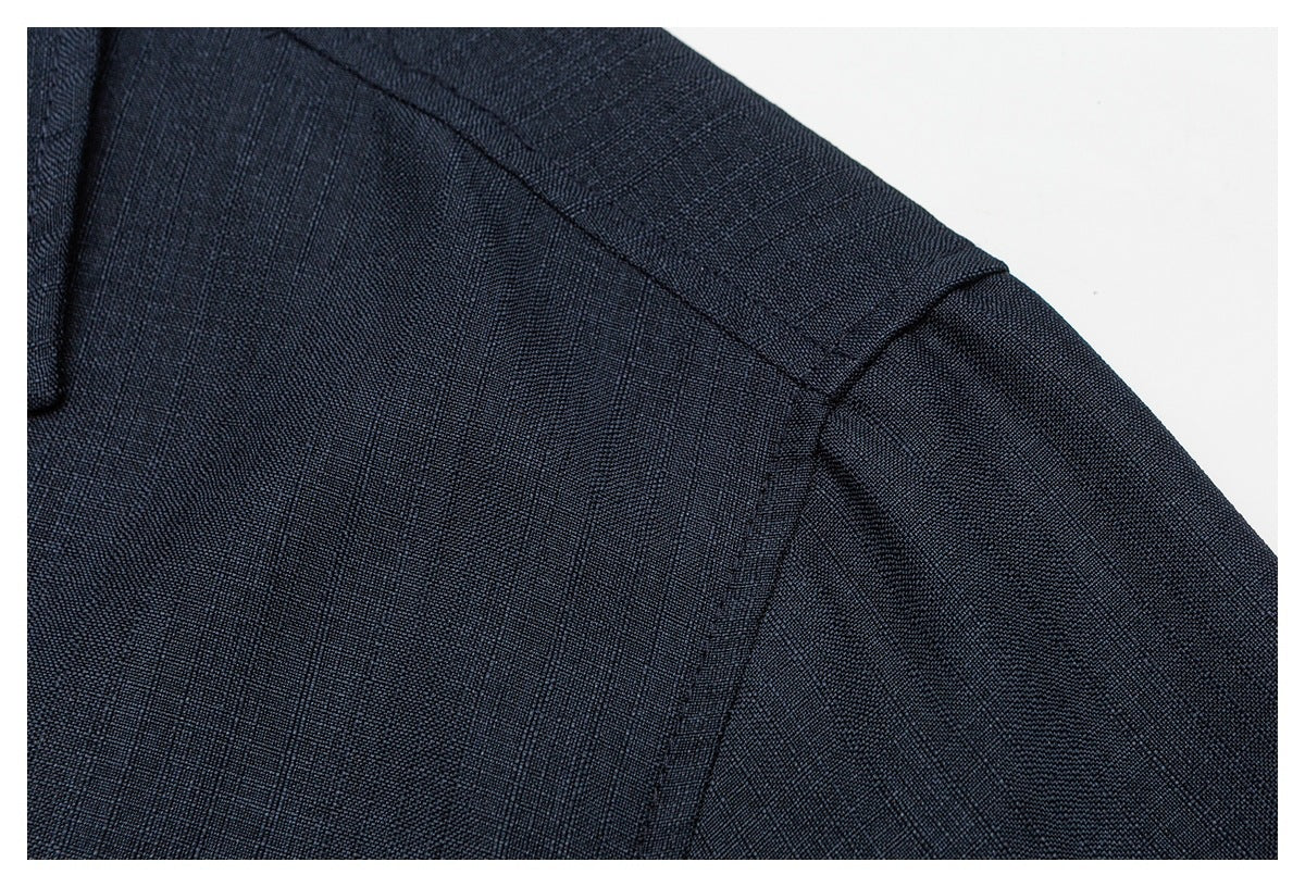 Close-up of a dark navy garment shoulder seam and textured fabric.