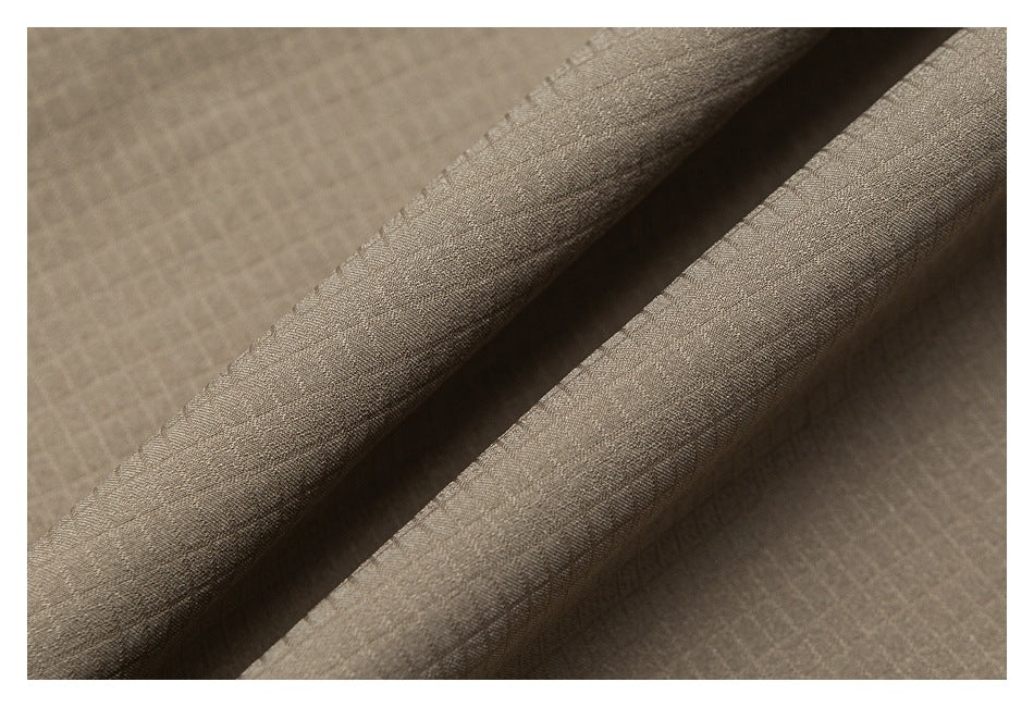 Close-up of taupe fabric folded into soft ridges, showing its fine woven texture.