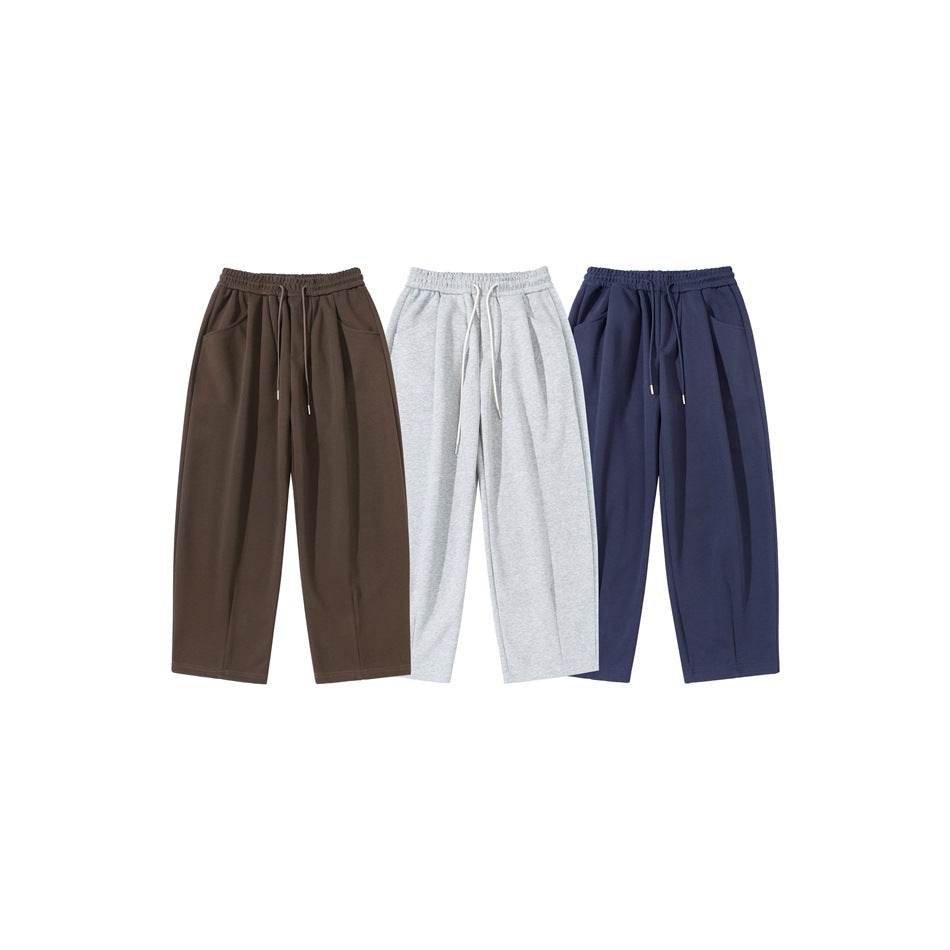 Three pairs of wide-leg drawstring sweatpants shown from the front in brown, light gray, and navy.