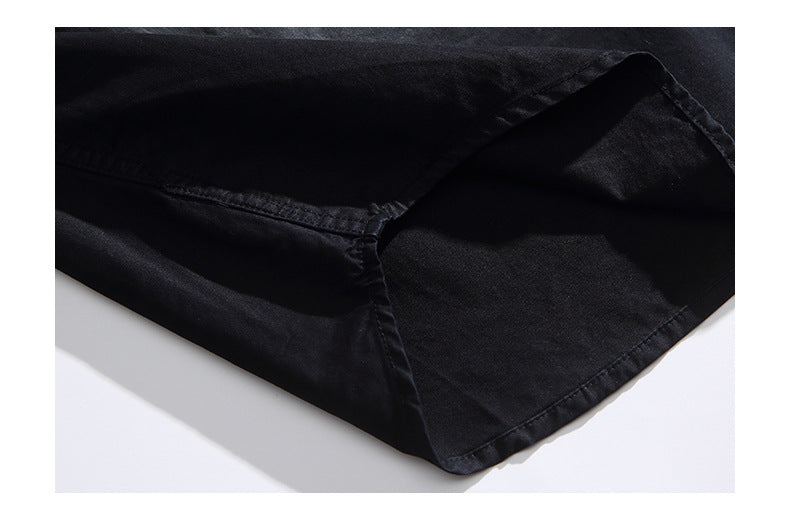 Close-up of a black garment hem with folded fabric and stitched seams.