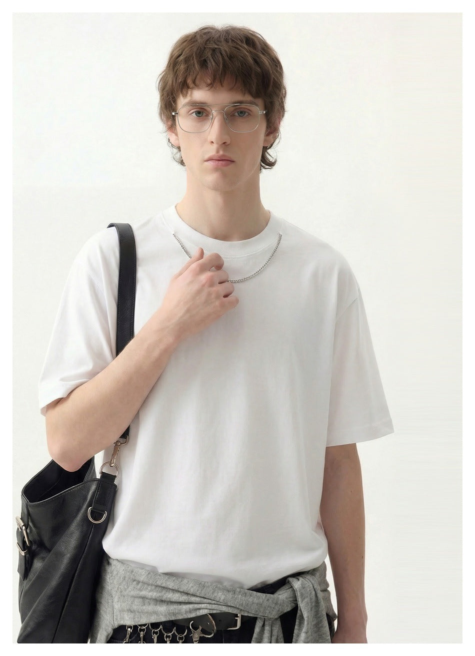 Close front view of a model wearing a plain white short-sleeve crew-neck T-shirt.