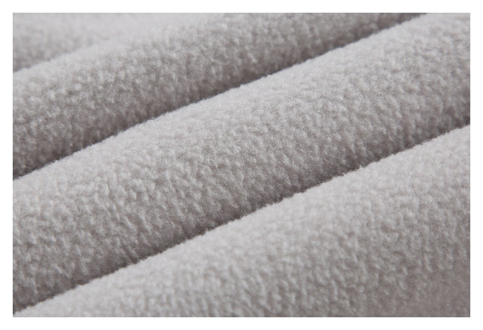 Extreme close-up showing the plush texture of pale gray fabric in folded layers.