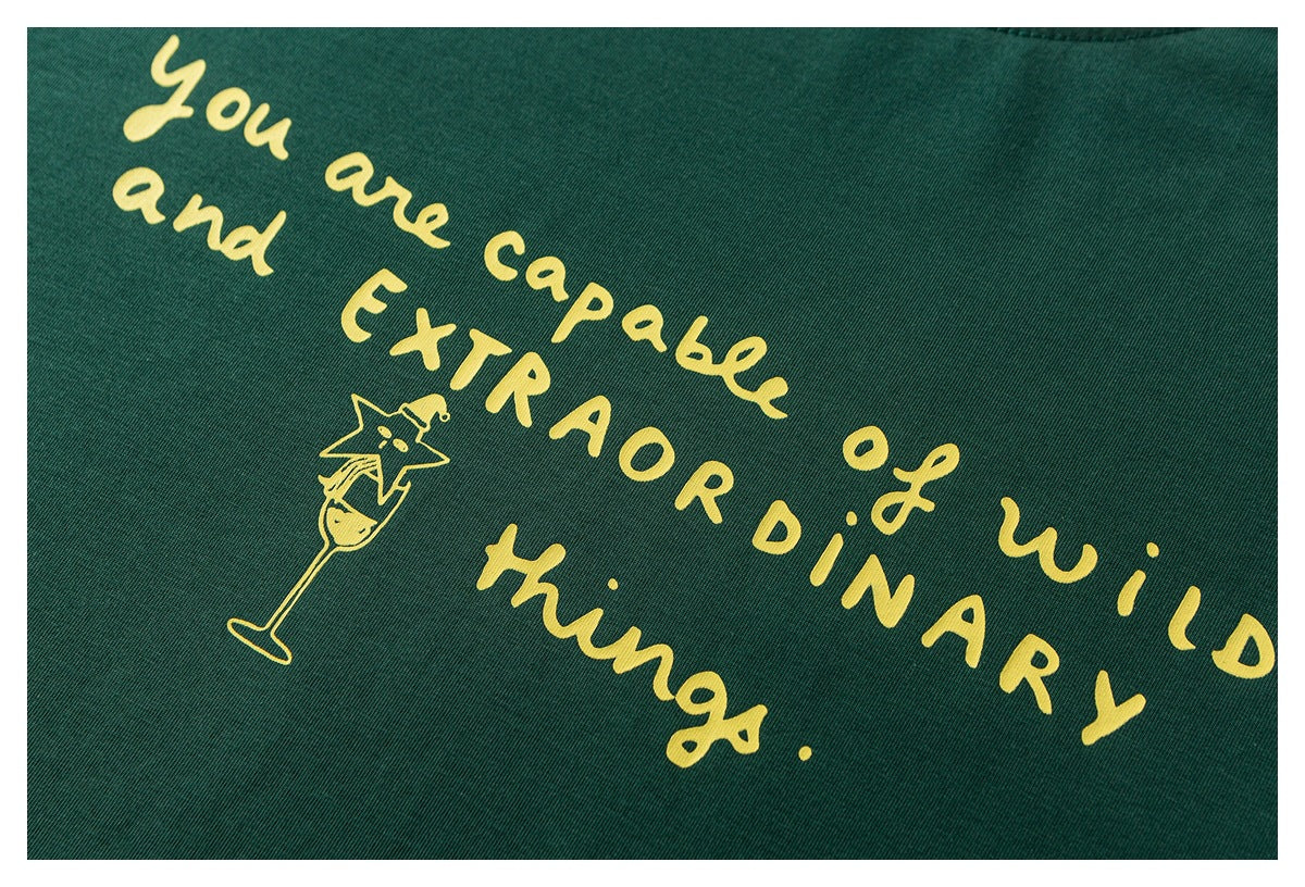 Yellow English lettering and a small cartoon figure printed on dark green shirt fabric.