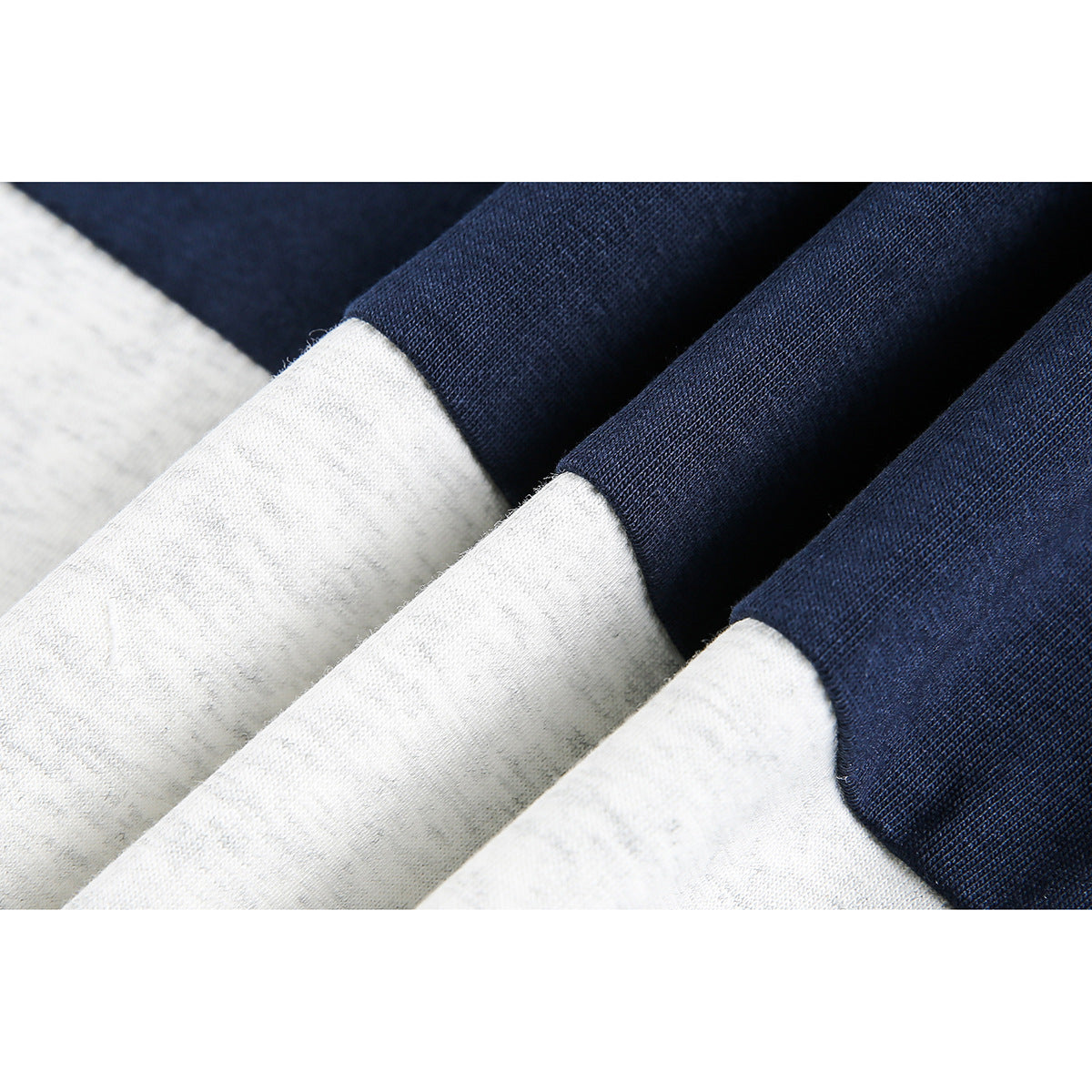 Close-up of gray and navy fabric panels showing their contrasting color-block seams and texture.