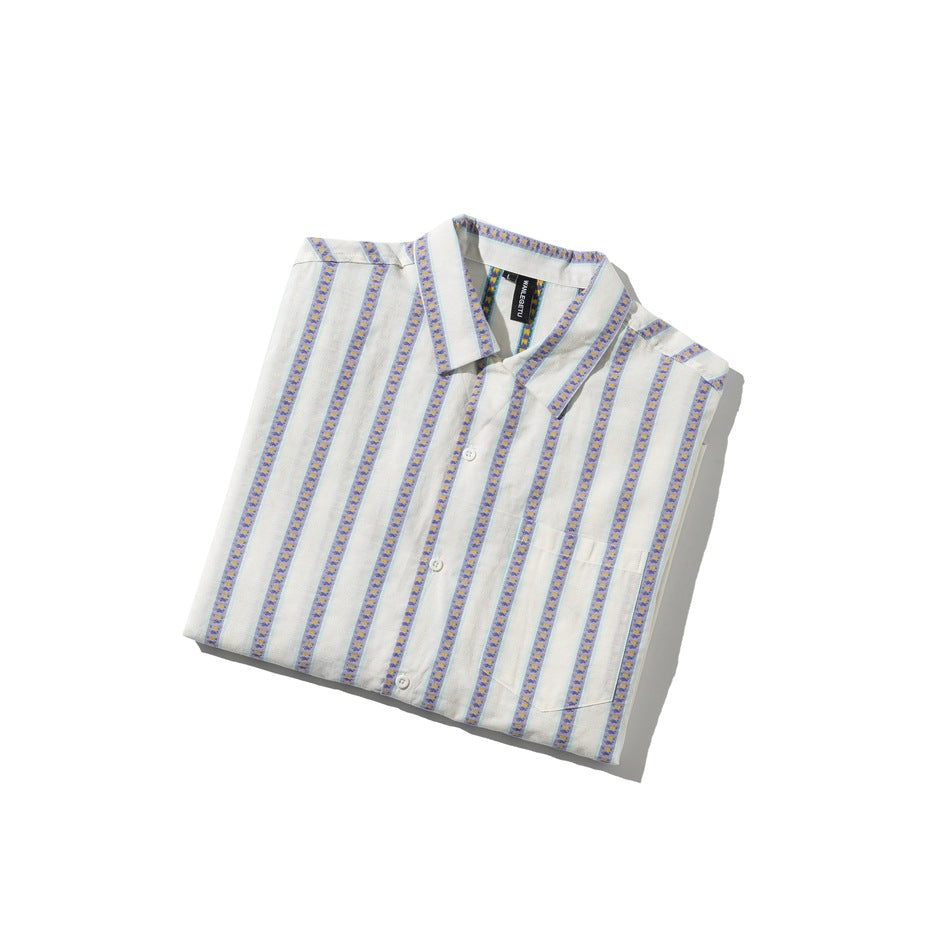 Folded ivory short-sleeve button-up shirt with purple floral stripe bands, turquoise edging, and a chest pocket.