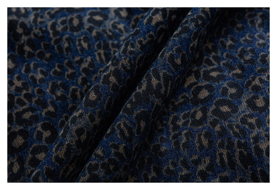 Close-up of folded dark blue leopard-print denim showing its textured surface.