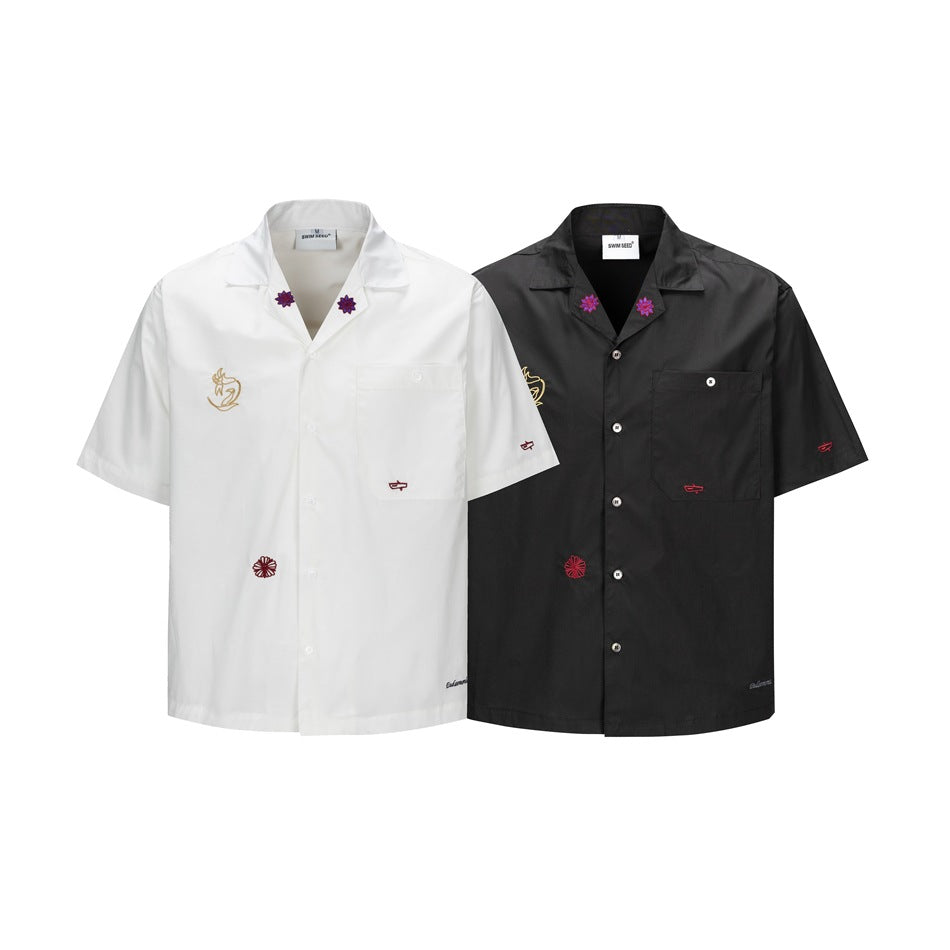 White and black short-sleeve button-up shirts displayed from the front, with small embroidered motifs and chest pockets.