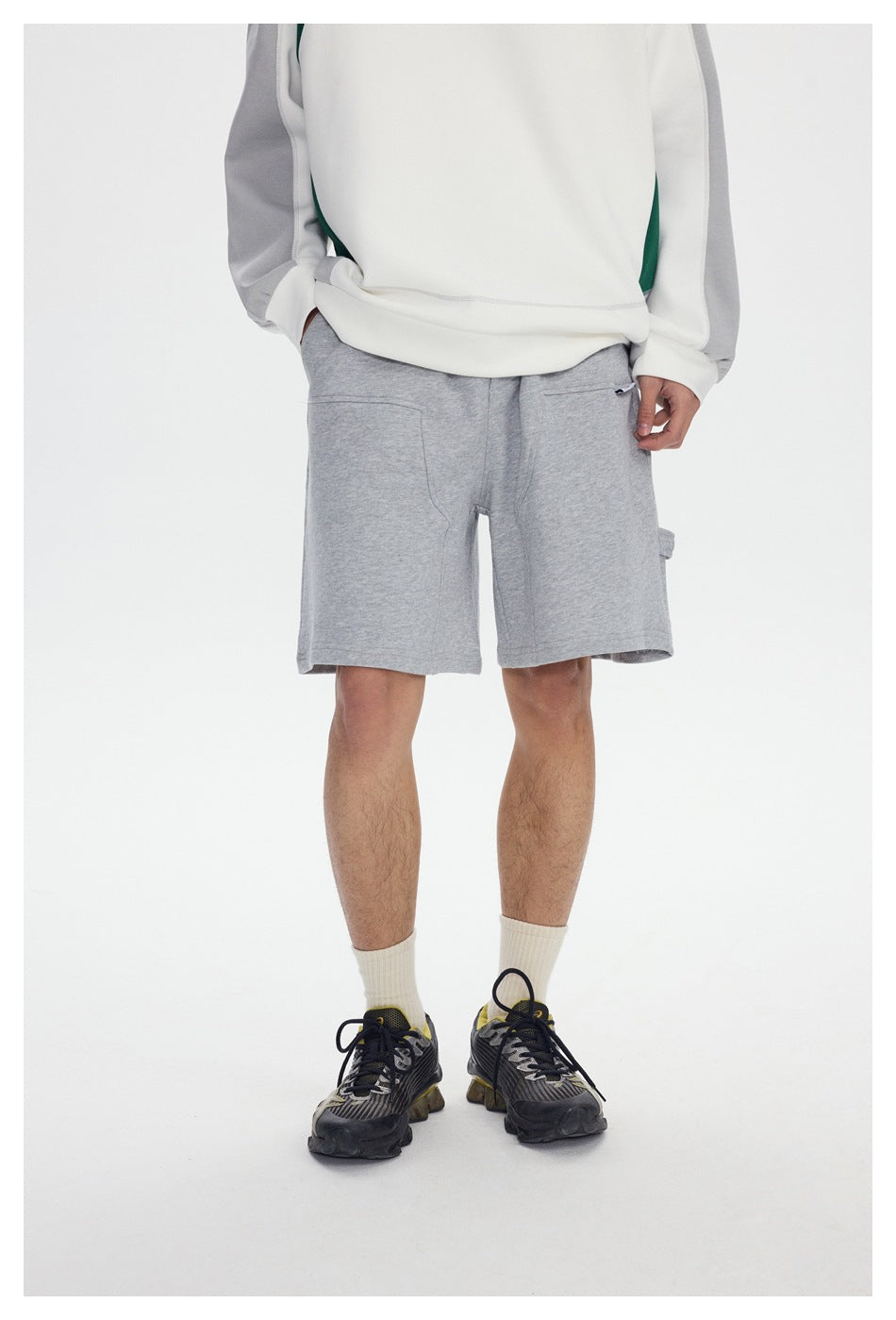 Front view of a model wearing light gray shorts with a small pocket and side utility loop.