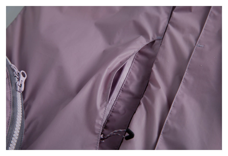 Close-up of the mauve jacket's zippered pocket and front zipper with water droplets on the fabric.