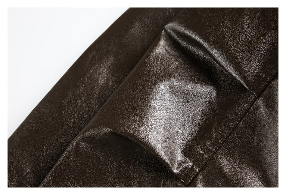 Close-up of dark brown pebbled material with a glossy finish and stitched panel seams.