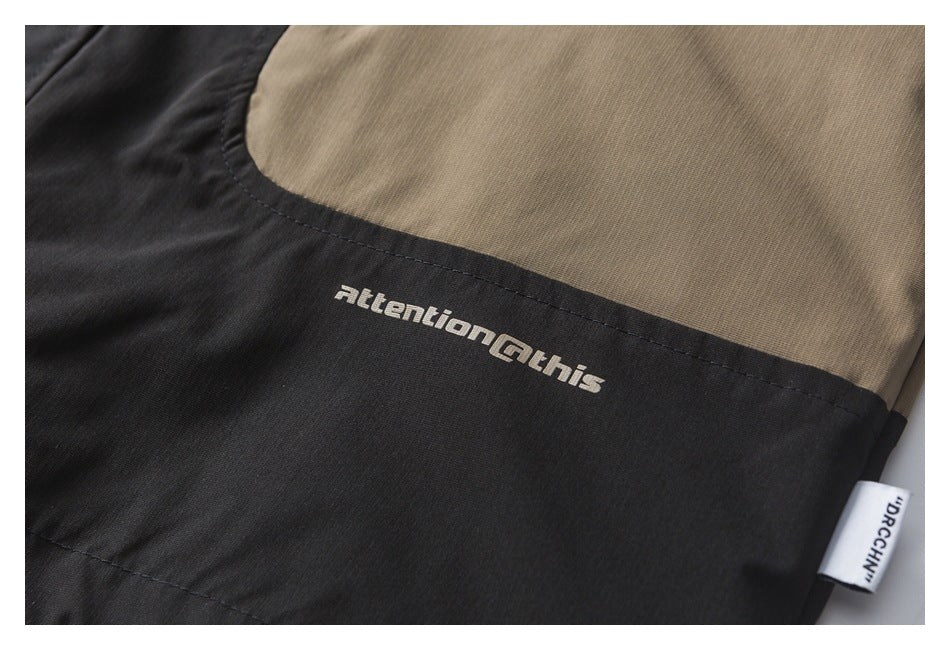 Close-up of a black and tan jacket with printed English text and a sewn side label.
