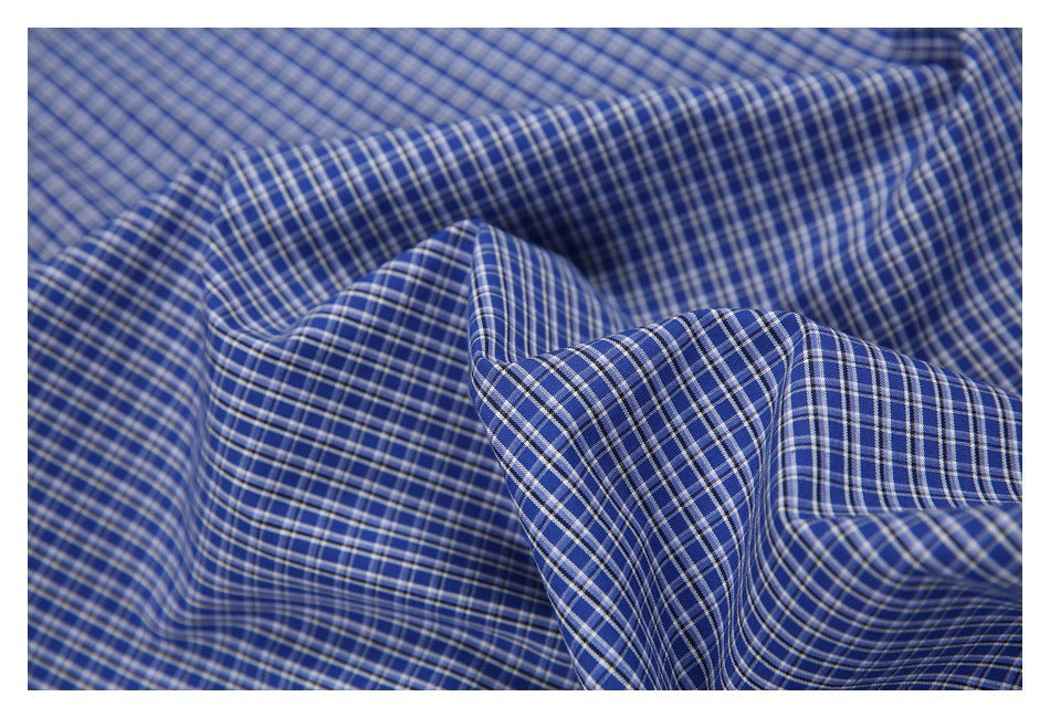 Close-up of draped blue fabric with a fine white and gray plaid pattern.