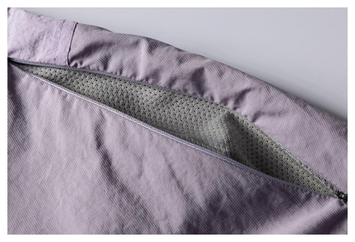 Close-up of mauve garment fabric opened to reveal a gray mesh panel and a zipper at the edge.
