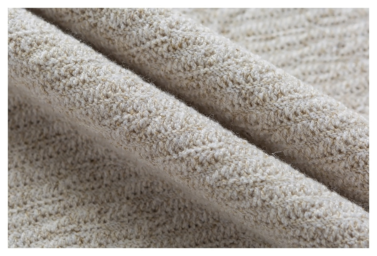 Macro view of the cream knit fabric folded to show its raised looped texture.