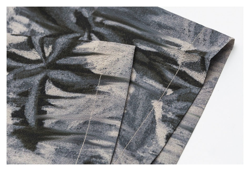 Close-up of the abstract-print shirt sleeve hem and stitching in gray, black, and light tones.