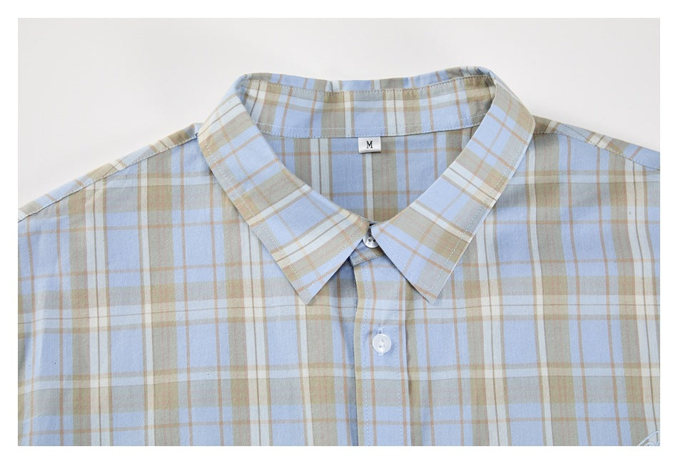 Flat-lay front view of a light blue, tan and white plaid button-up shirt with a pointed collar.