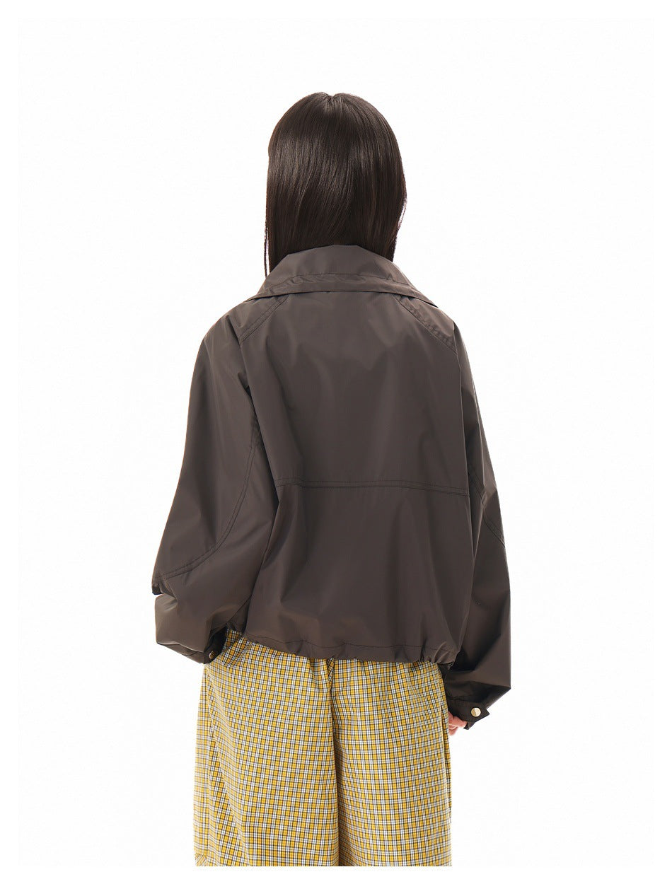 Back view of a person wearing a dark brown jacket with a wide collar and long sleeves.