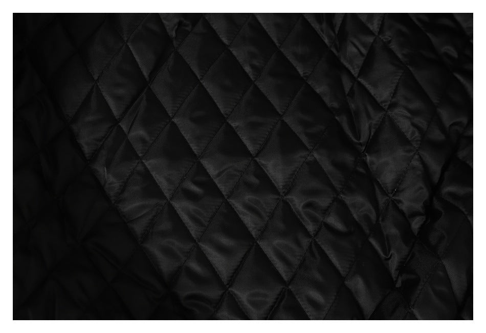 Close-up of black diamond-quilted jacket lining.