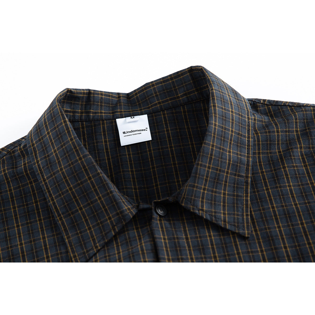 Close-up of a dark navy plaid shirt collar, top button, and sewn-in neck label.