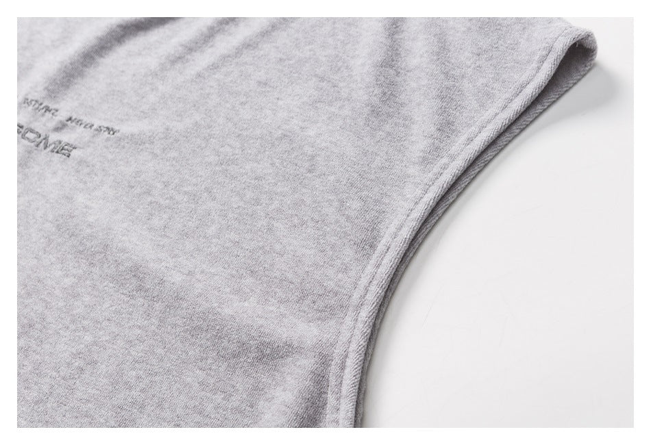 Close-up of heather-gray garment fabric with a curved stitched edge and partially visible dark lettering.