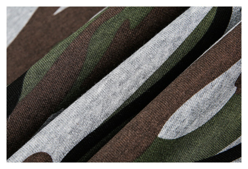 Macro view of the green, brown, gray, and black camouflage fabric texture.