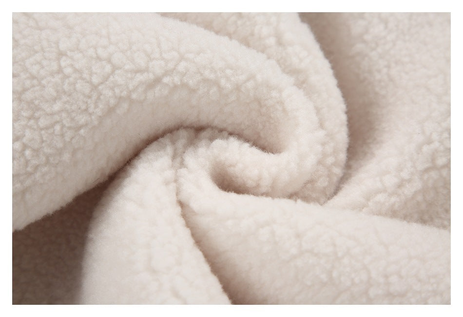 Close-up of folded cream sherpa fabric showing its soft, textured pile.