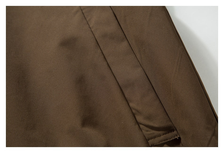 Close-up of a stitched vertical flap or seam on a brown garment.