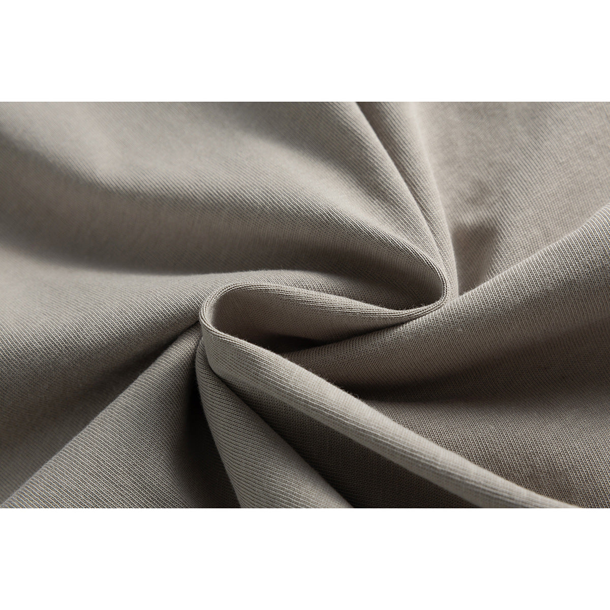 Macro view of taupe fabric gathered into folds, showing its fine knit texture.