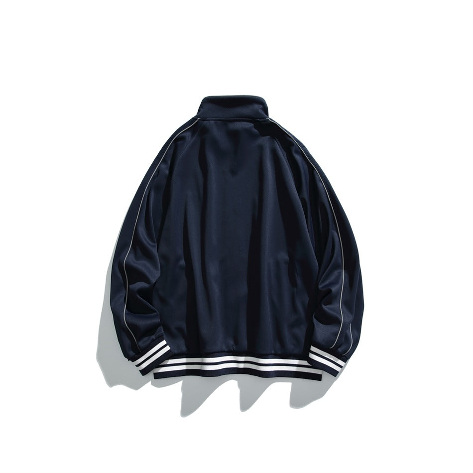 Back view of a navy track jacket laid flat, with white piping and striped cuffs and hem.