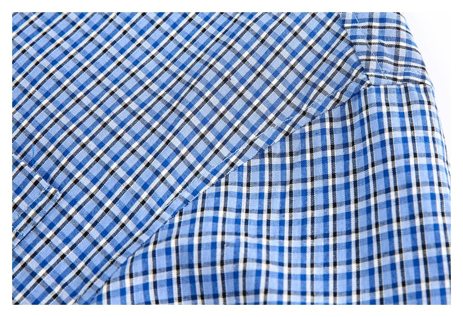 Close-up of blue, white and black plaid fabric with an overlapping stitched seam.