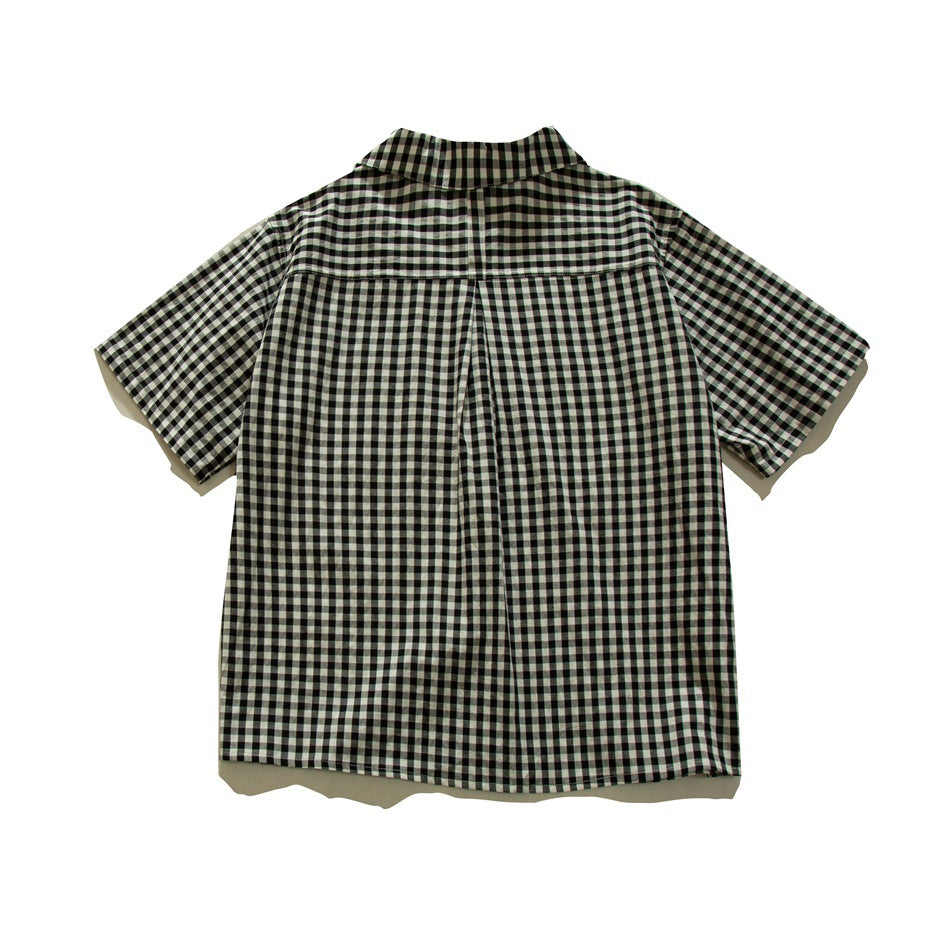 Back view of black and white gingham short-sleeve shirt showing yoke seam and center back pleat