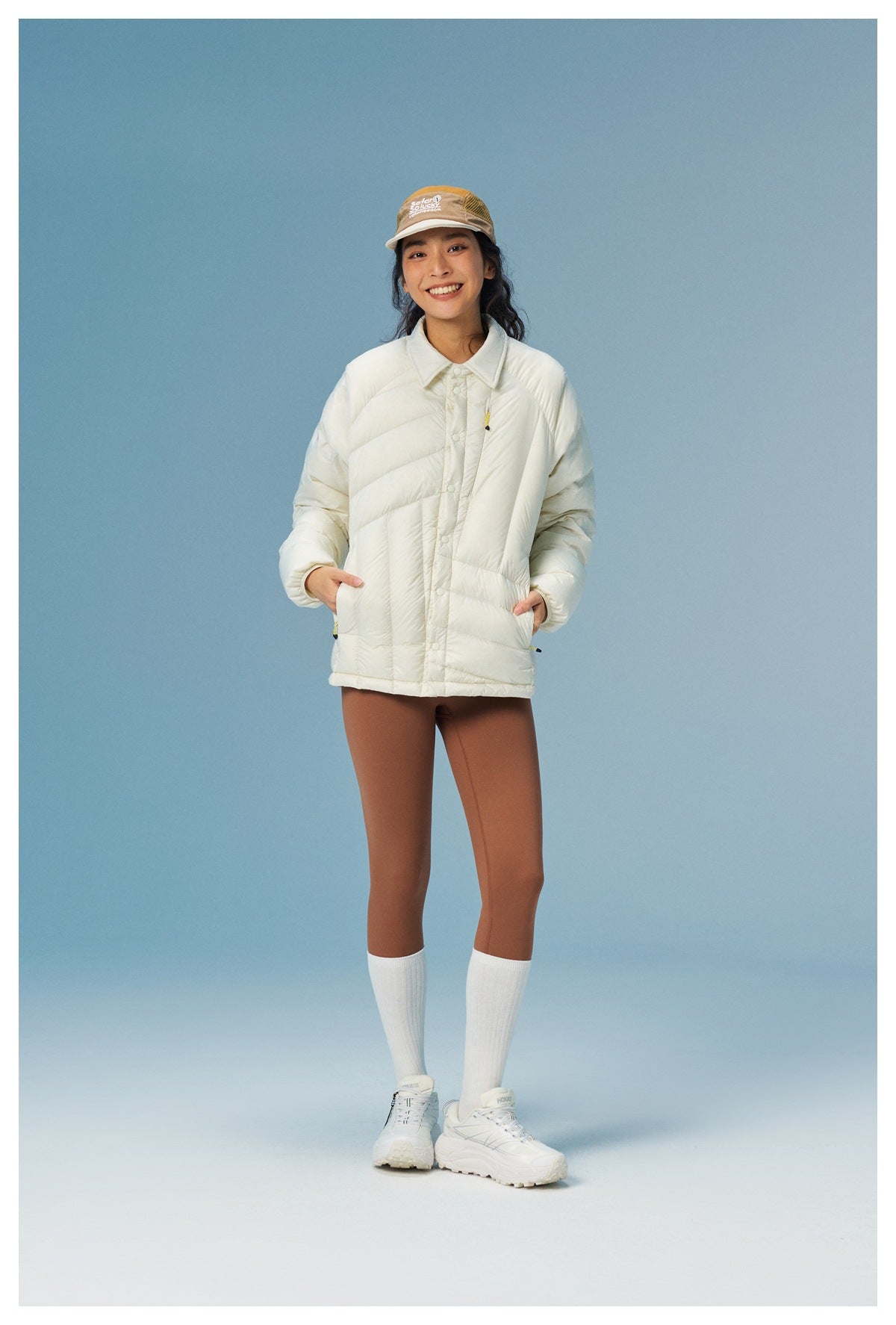 Model wearing an ivory quilted button-front jacket with a pointed collar and side pockets, paired with brown leggings.