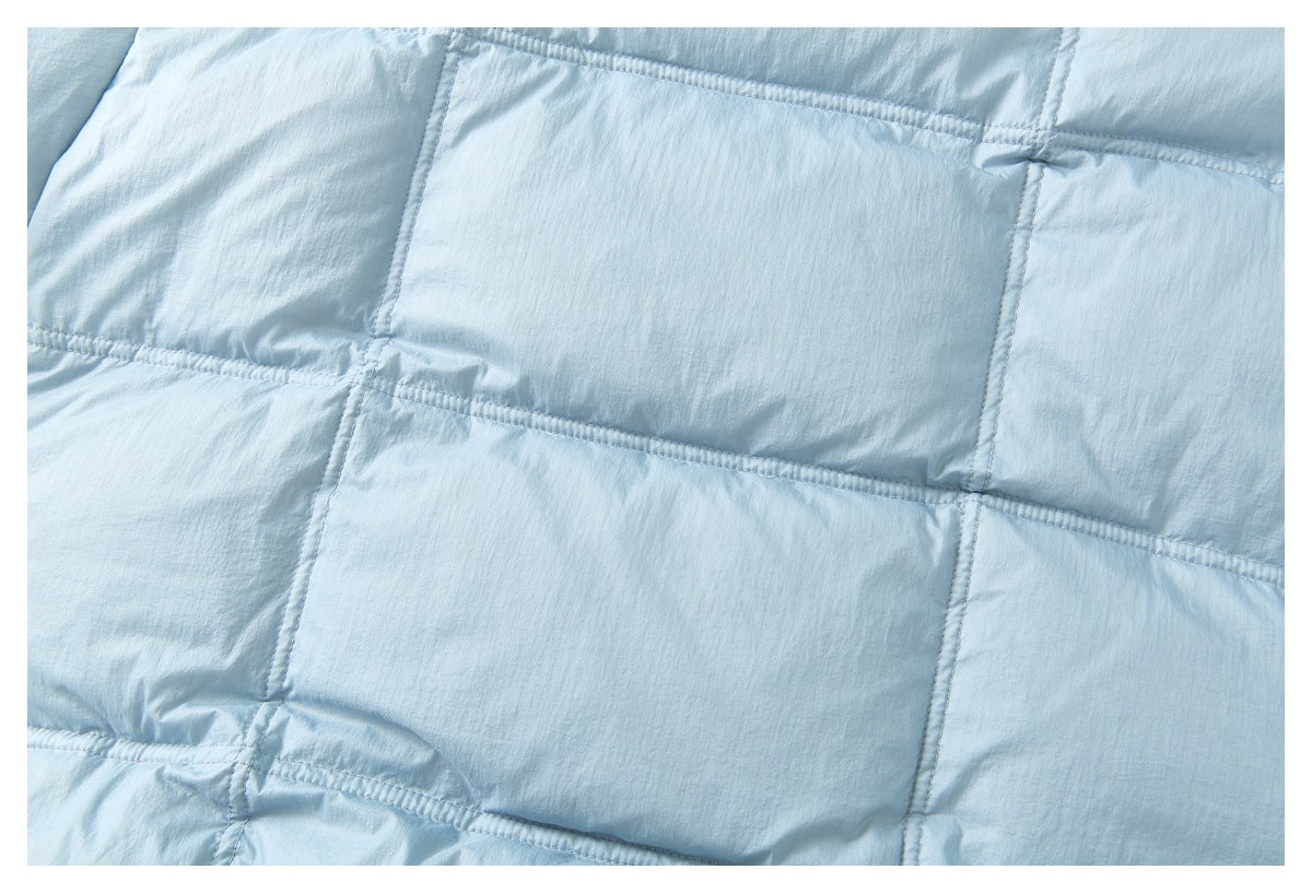 Close-up of light blue quilted jacket fabric with rectangular stitched panels.