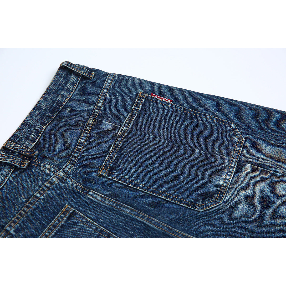 Close-up of the dark blue jeans' back waistband and stitched rear pocket.