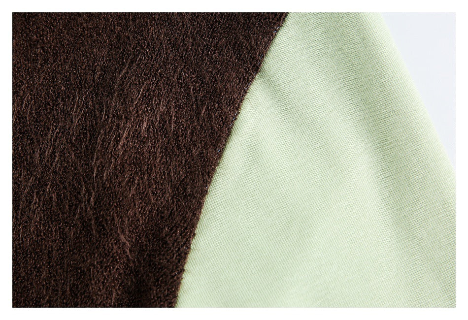 Close-up of a dark brown textured panel beside smooth pale green fabric.