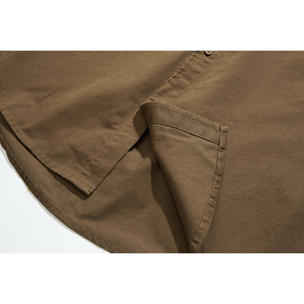 Close-up of the brown shirt's short sleeve and curved hem, showing the stitching and fabric.