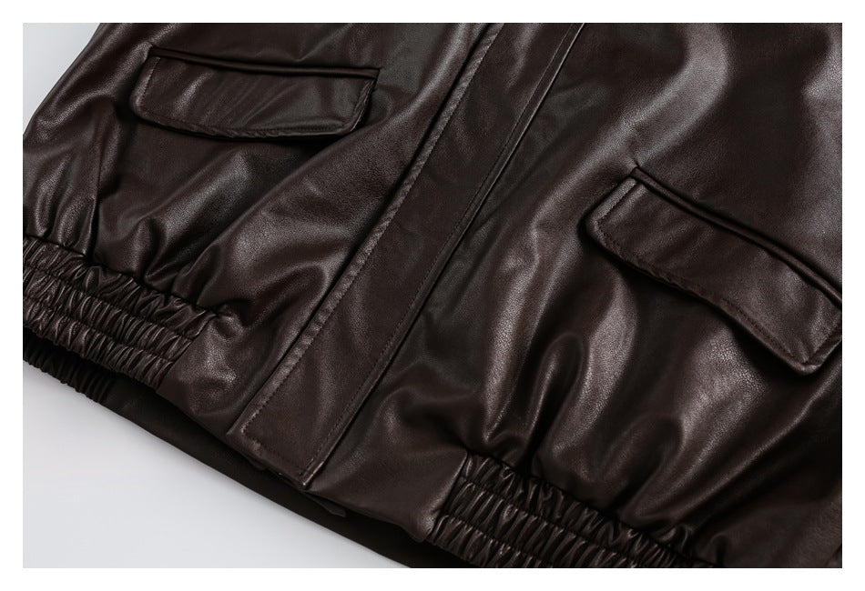 Close-up of two flap pockets, a front placket, and gathered elastic waist on a dark brown garment.