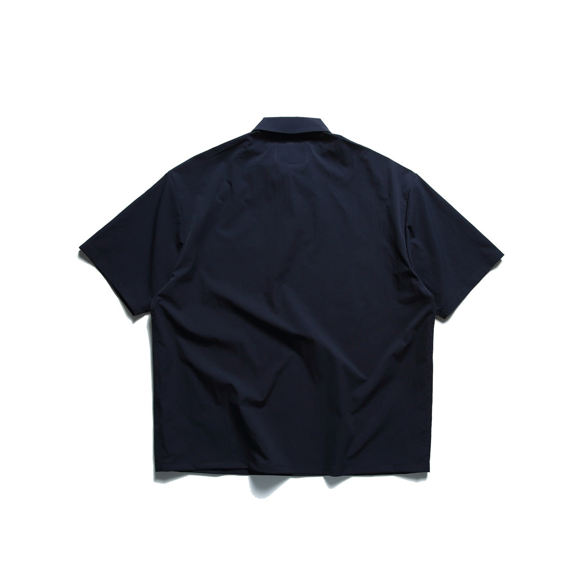 Back view of a navy short-sleeve collared shirt laid flat on a white background.