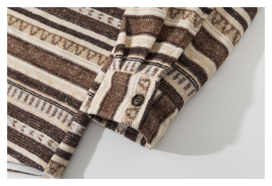 Close-up of a buttoned cuff on brown, cream, and tan striped fabric.