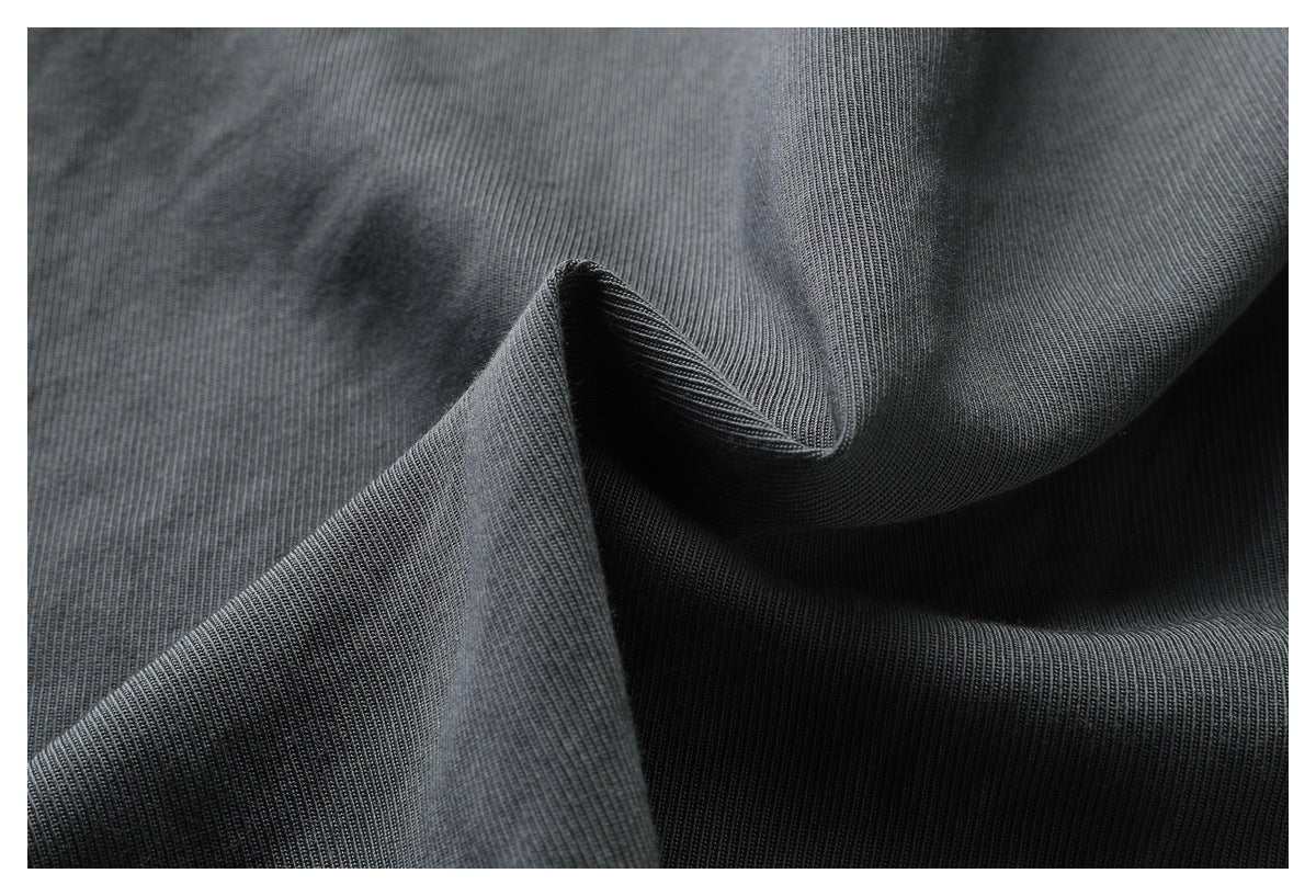 Charcoal fabric draped into folds, highlighting its fine vertical rib texture.