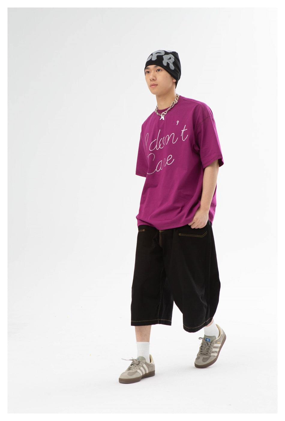 Model wearing a magenta oversized T-shirt with white cursive lettering, shown from the front.