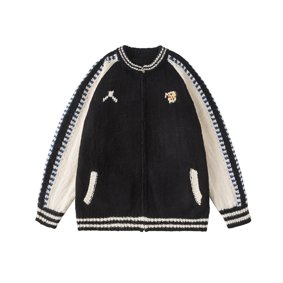 Black knit zip cardigan jacket with cream raglan sleeves, blue zigzag trim, striped ribbed cuffs and hem, front flat lay