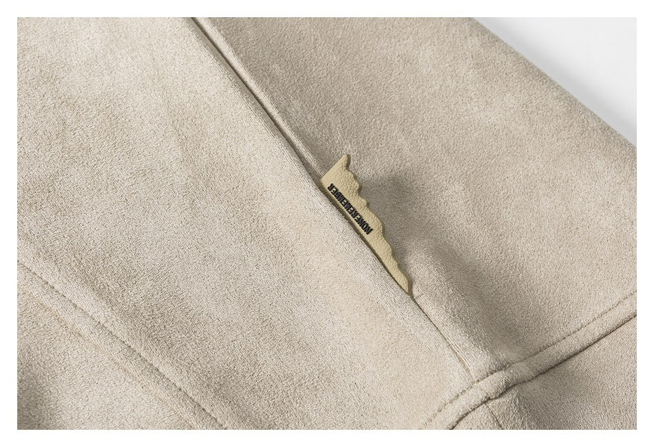 Close-up of a beige garment seam with a small sewn fabric label.