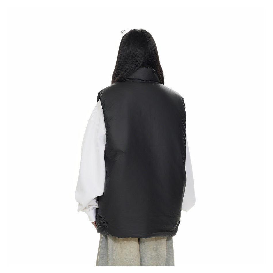 Rear view of a model wearing a plain black padded vest over a white sweatshirt.